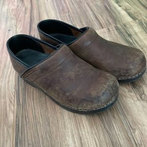 Brown Dansko clogs.